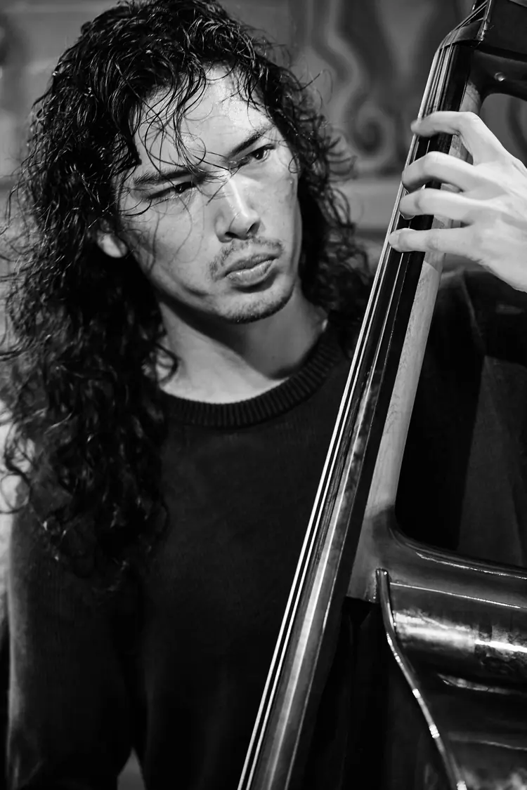Close portrait of a double bassist concentrating on his playing, in black and white — Jazz photography by Michaël Gramm