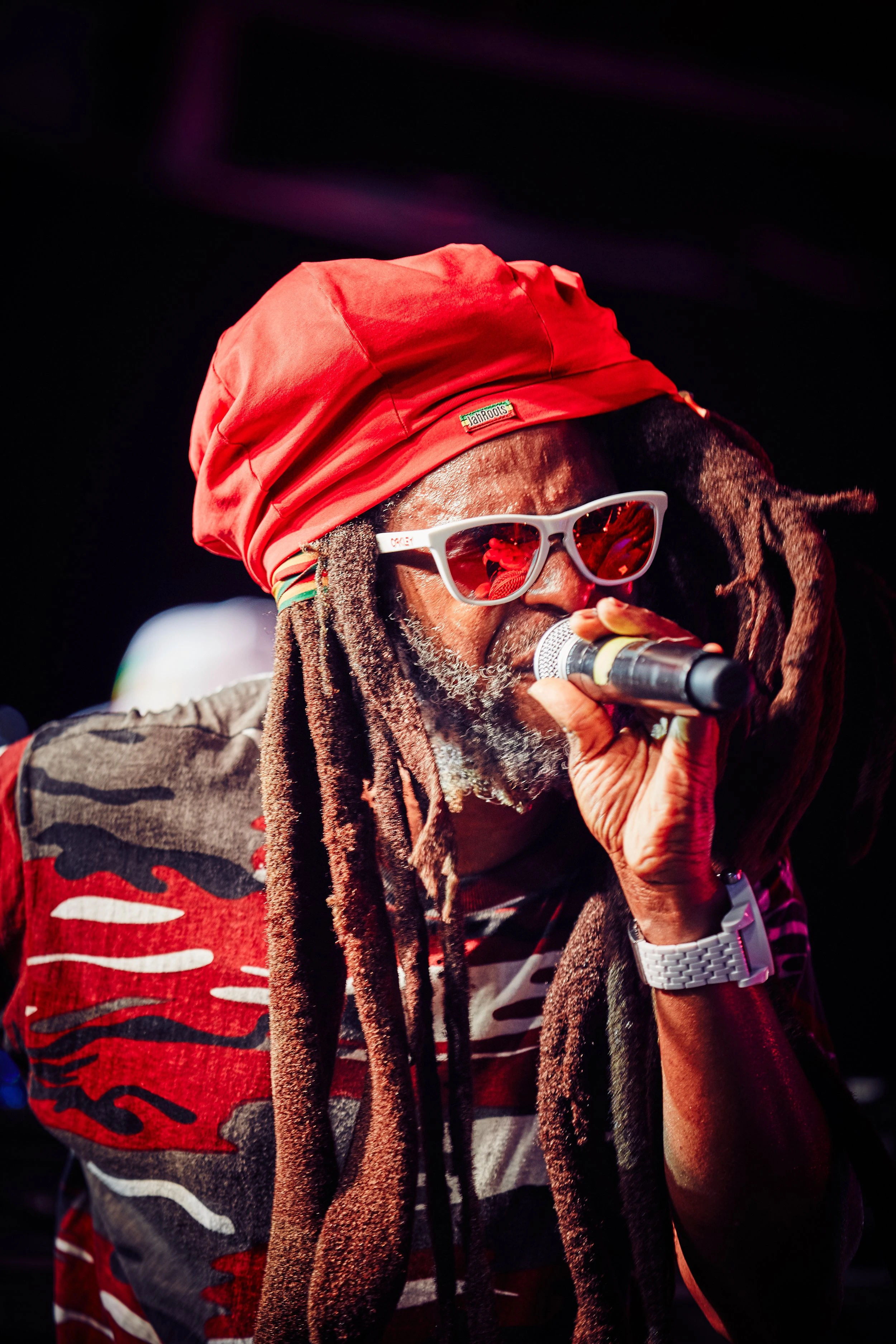 Close view of a singer with a red head covering — Music series — photograph by Michaël Gramm